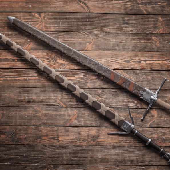 Detailed close-up of the handcrafted hilt of Geralt of Rivia steel sword replica, featuring natural leather grip, carbon steel crossguard, and surgical steel pommel, showcasing premium materials and historical construction techniques ideal for Witcher cosplay and LARP events.